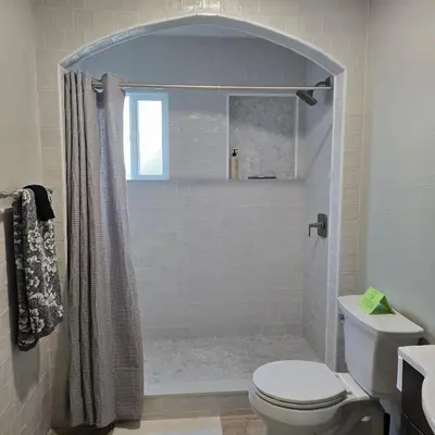 a white bathroom with a shower and a toilet at Wise in San Diego