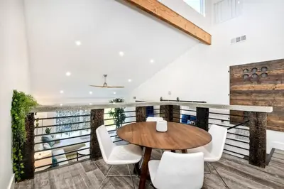 a dining room with a wooden table and white chairs at Sea Bluff - Direct Beach Access in Encinitas