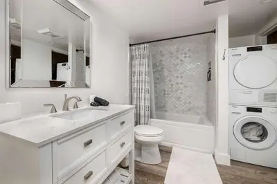 a white bathroom with a sink and a washing machine at Sea Bluff - Direct Beach Access in Encinitas