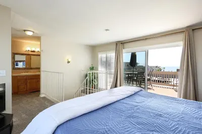 a bedroom with a bed and a balcony at Oceanside Beach Condos in Oceanside
