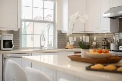 a kitchen with white cabinets and a plate of fruit on a counter at Grand Luxury 4BD Estate in Irvine in Irvine