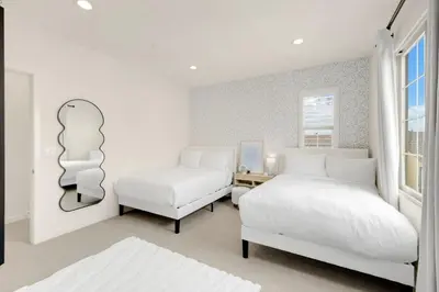 a white bedroom with two beds and a window at Grand Luxury 4BD Estate in Irvine in Irvine