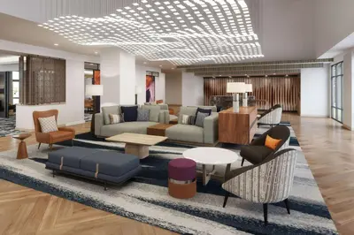 a living room with couches and tables and chairs at Tempo By Hilton San Diego Del Mar in San Diego
