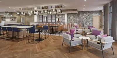 a restaurant with a bar with purple chairs and tables at Tempo By Hilton San Diego Del Mar in San Diego