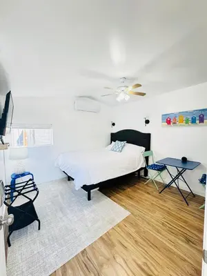 a white bedroom with a bed and a table at Cozy Guesthouse - 15 Min to Downtown SD in Chula Vista