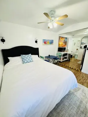 a bedroom with a white bed and a ceiling fan at Cozy Guesthouse - 15 Min to Downtown SD in Chula Vista