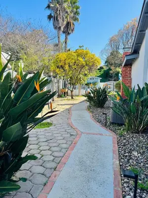 a stone walkway in a residential yard with plants at Cozy Guesthouse - 15 Min to Downtown SD in Chula Vista