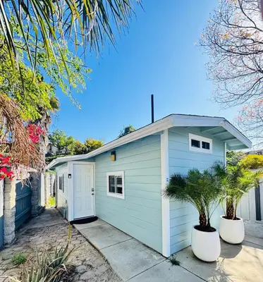 a white garage with two trees in front of it at Cozy Guesthouse - 15 Min to Downtown SD in Chula Vista