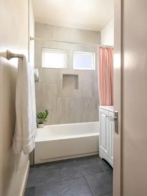 a bathroom with a white tub and a shower at Cozy Ocean Beach Bungalow in San Diego
