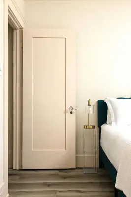 a white door in a bedroom with a bed at Cozy Ocean Beach Bungalow in San Diego