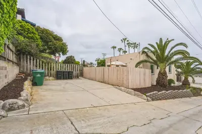 a fence next to a sidewalk next to a house at Cozy Ocean Beach Bungalow in San Diego