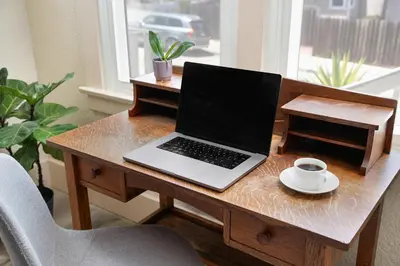 a laptop computer sitting on a wooden desk with a cup of coffee at Cozy Ocean Beach Bungalow in San Diego