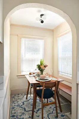 a dining room with a table and two windows at Cozy Ocean Beach Bungalow in San Diego