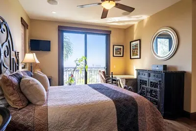 a bedroom with a bed and a large window at Pool Hot Tubs Views - Castillo de Windsor in San Diego