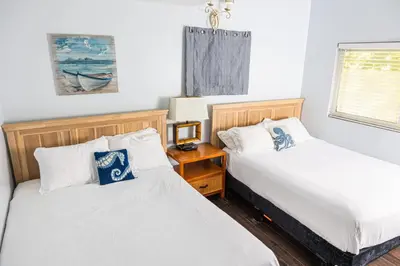 a bedroom with two beds and a night stand at Balboa Escape An Iconic Stay in Newport Beach