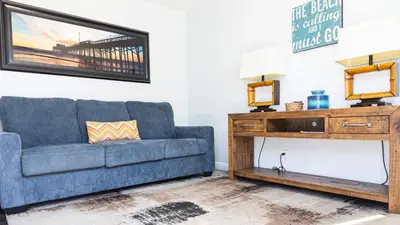 a living room with a blue couch and a table at Balboa Escape An Iconic Stay in Newport Beach