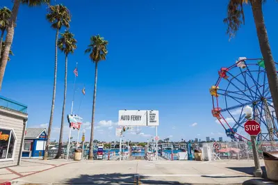 a carnival with a ferris wheel and palm trees at Balboa Escape An Iconic Stay in Newport Beach