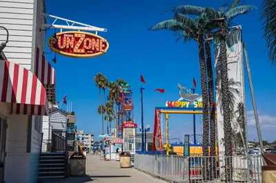 a boardwalk with a amusement park and a sign at Balboa Escape An Iconic Stay in Newport Beach
