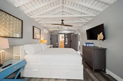a bedroom with a white bed and a tv at Bayside Getaway Waterfront in Newport Beach