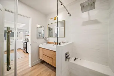 a white bathroom with a sink and a mirror at Bayside Getaway Waterfront in Newport Beach