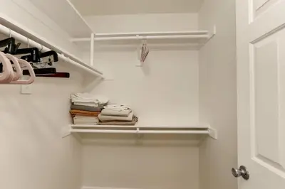 a closet with white walls and a door with towels at SoCal's Finest Gem on Dahlia in Corona del Mar