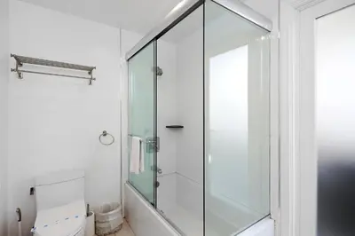 a glass shower in a bathroom with a toilet at Grand Canal Getaway - Balboa Island in Newport Beach