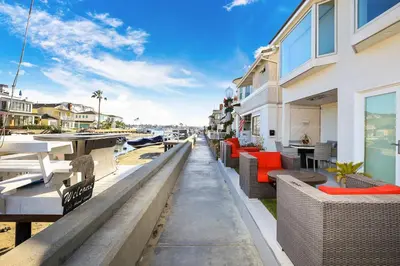 a marina with tables and chairs next to a building at Grand Canal Getaway - Balboa Island in Newport Beach