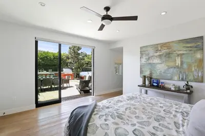 a bedroom with a bed and a ceiling fan at Private Wading Pool Home with Patio in Corona del Mar