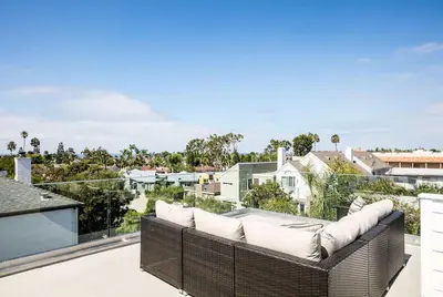 a wicker couch on the balcony of a house at A True Vacation Masterpiece in Corona del Mar