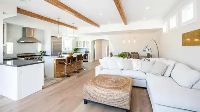 a living room with a white couch and a kitchen at A True Vacation Masterpiece in Corona del Mar