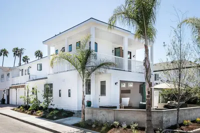 a white house with palm trees in front of it at A True Vacation Masterpiece in Corona del Mar