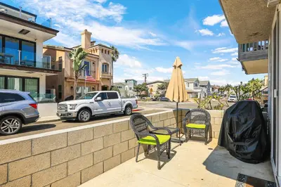 a patio with chairs and a table and a umbrella at Newport Retreat A - Fab for 4 in Newport Beach