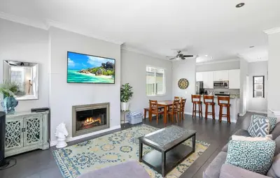 a living room with a fireplace and a kitchen at Newport Retreat B - Walk to Sandy Beaches in Newport Beach