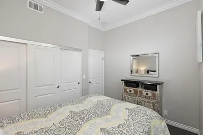 a white bedroom with a bed and a mirror at Newport Retreat B - Walk to Sandy Beaches in Newport Beach