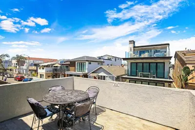 a patio with a table and chairs on a balcony at Newport Retreat B - Walk to Sandy Beaches in Newport Beach