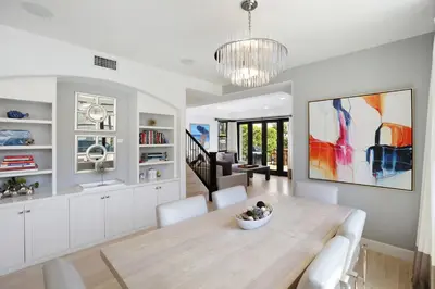 a dining room with a wooden table and chairs at Poinsettia Palms - Chic & Luxe Patio Near Beach in Corona del Mar