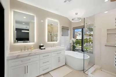 a white bathroom with a tub and a sink at Poinsettia Palms - Chic & Luxe Patio Near Beach in Corona del Mar