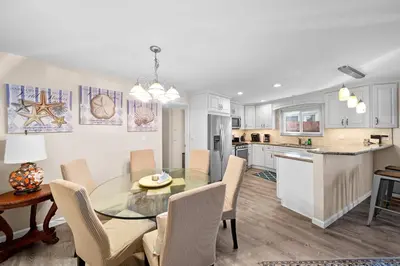 a kitchen and dining room with a glass table and chairs at Ruby Villa A - Stay for 6 in Newport Beach