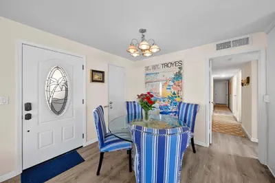 a dining room with a glass table and blue chairs at Ruby Villa B - Upper Unit for 6 in Newport Beach