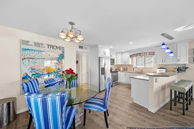 a kitchen with a glass table and blue chairs at Ruby Villa B - Upper Unit for 6 in Newport Beach