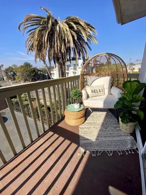 a balcony with a chair and a palm tree at Bright & Quiet 1-Bed Condo with Balcony in San Diego