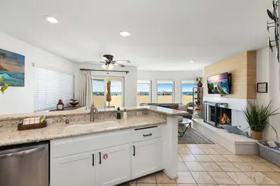 a kitchen with a sink and a living room at Seashore Sun and Fun - On Beach in Newport Beach