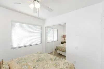 a bedroom with a bed and a ceiling fan at Seashore Sun and Fun - On Beach in Newport Beach