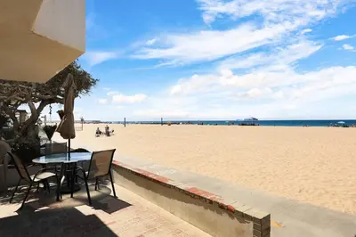 a table and chairs on the beach near the sand at Seashore Sun and Fun - On Beach in Newport Beach