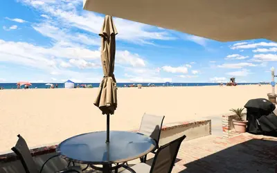 a table with an umbrella on the beach at Seashore Sun and Fun - On Beach in Newport Beach