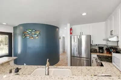 a kitchen with a sink and a refrigerator at Seashore Sun and Fun - On Beach in Newport Beach