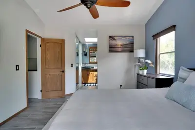 a bedroom with a large bed with a ceiling fan at Serene hillside oasis with pool - 20 min to beach in Oceanside
