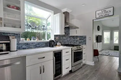 a kitchen with white cabinets and a large window at Serene hillside oasis with pool - 20 min to beach in Oceanside