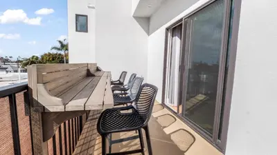 a balcony with chairs and a wooden table on a building at Rise Suites Oceanside in Oceanside