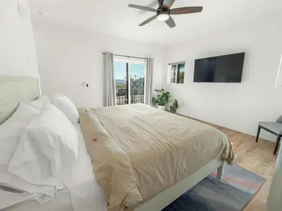 a bedroom with a bed and a flat screen tv at Rise Suites Oceanside in Oceanside